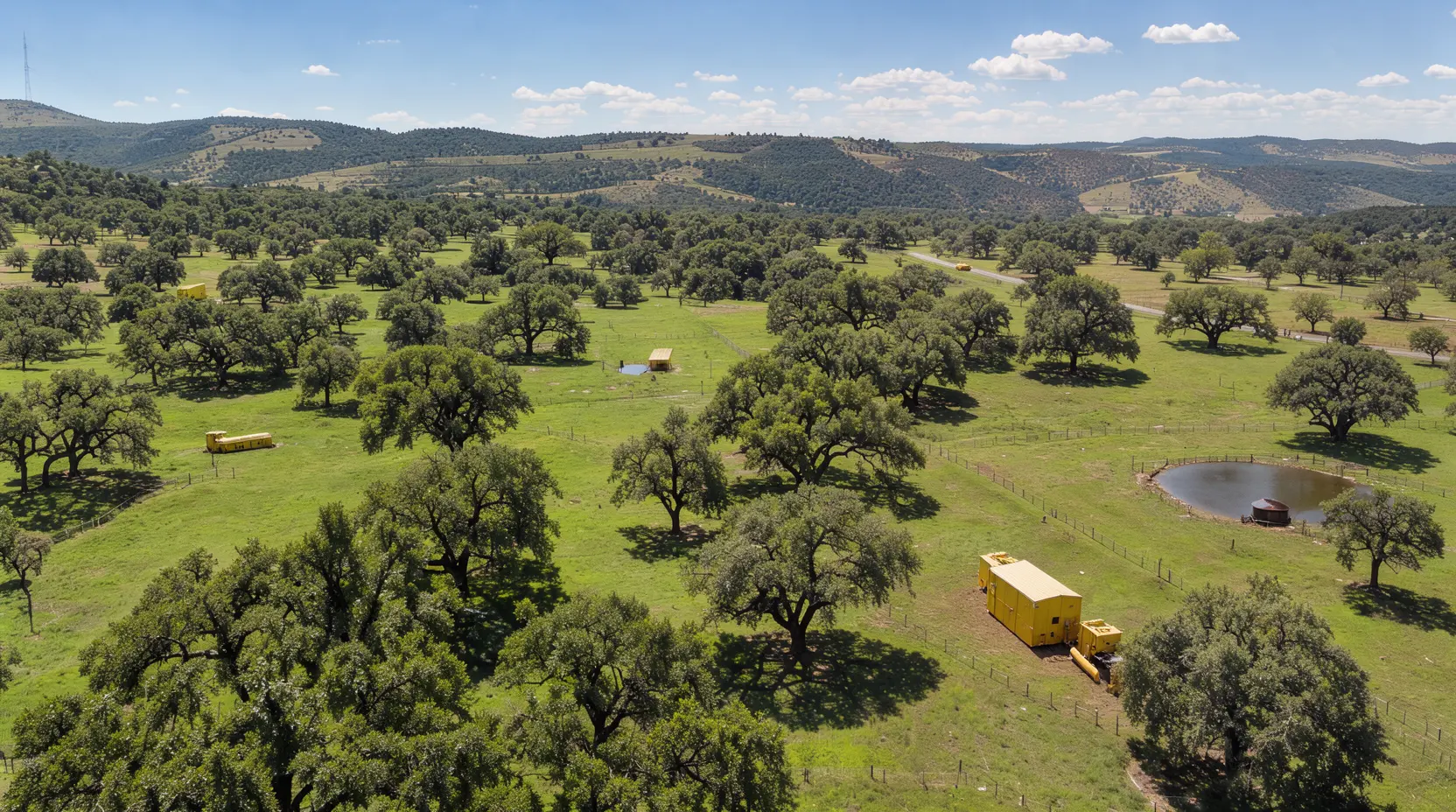Aerial view of Hill Country ranch land with live oaks and a stock tank, land clearing in Kendall County, Texas
